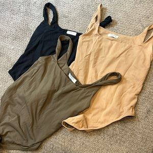 Three aritzia Babaton body suits (black, green, tan)